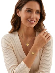 Mujer con collar y pulsera de corazón dorado.